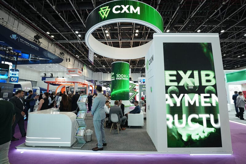 บูธนิทรรศการของ CXM ที่จัดแสดงโครงสร้างพื้นฐานด้านการชำระเงินและการเทรด